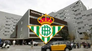 El escudo del Real Betis con un hospital de España de fondo.